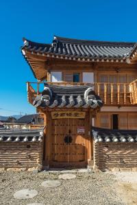 a wooden building with a gate and a roof at Siwoowadang in Gyeongju