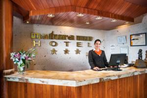 a woman sitting at a counter with a laptop at Natura Inn Hotel in Arequipa