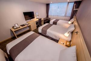 Postel nebo postele na pokoji v ubytování Hotel Shalom Jeju