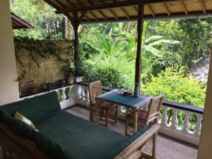 a screened in porch with a couch and a table at White Lotus Oasis in Ubud