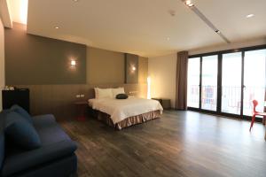 ein Hotelzimmer mit einem Bett und einem Sofa in der Unterkunft Funson Hotel in Eluan