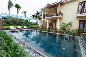 a swimming pool in front of a house at Lama Villa Hoi An in Hoi An