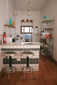 a kitchen with two bar stools in front of a counter at La Casa de Don Santiago Townhouse in Copan Ruinas