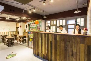 a group of people sitting at a counter in a restaurant at RF Hotel - Sanchong in Taipei