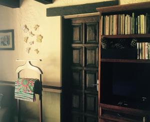 a room with a book shelf and a lamp and a television at Casa Palomas Bed and Breakfast in San Juan Cosalá