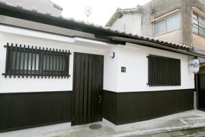 a white and black house with a black garage at Daisenji Lodge Ing 墨 地下鉄鞍馬口駅から徒歩1分 in Kyoto