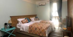 Un pat sau paturi într-o cameră la Shell Villa apartel resort