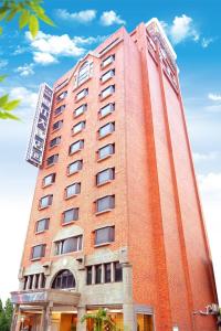 a tall red brick building with a sky in the background at Unic Hotel in Chiayi City