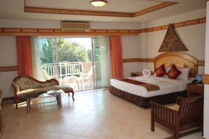 a bedroom with a bed and a balcony at Diana Garden Resort - SHA Extra Plus in Pattaya +109 photos