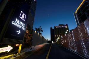 une rue vide la nuit avec un panneau d'auberge colonie d'hôtel dans l'établissement Paju Golden Hill, à Paju