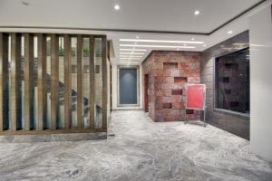 a lobby with a staircase and a brick wall at Red Carlton in Kānpur