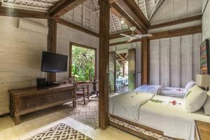 a bedroom with a large bed and a tv at Wayang Retreat in Canggu +81 photos