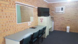 a room with a table and chairs and a television at Tiaro Motor Inn in Tiaro