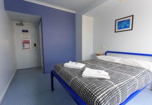 um quarto com uma cama com duas toalhas em YHA Cairns Central em Cairns