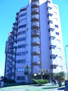 a tall white apartment building with palm trees in front of it at ESPECTACULAR Alem 5007 piso 7 in Mar del Plata