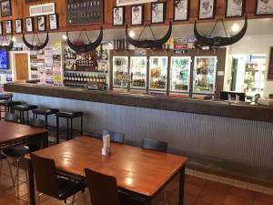 a restaurant with tables and chairs and a bar at Roebuck Plains Roadhouse in Broome +1 photo