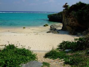 una playa de arena con el océano en el fondo en Huuran, en Nakijin