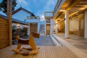 - un banc en bois sur une terrasse couverte dans l'établissement Jianshe Inn, à Lijiang