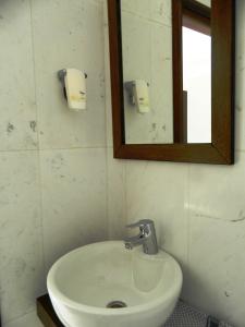 uma casa de banho com um lavatório branco e um espelho. em Arcadia Suites & Spa em Galatás