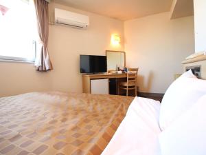 1 dormitorio con 1 cama y escritorio con ordenador en Hotel LC Gifu Hashima, en Hashima