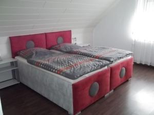 un lit avec tête de lit rouge dans une chambre dans l'établissement Ferienwohnung Berne, à Berne