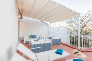 a patio with white chairs and a table at Casa Malu in Positano