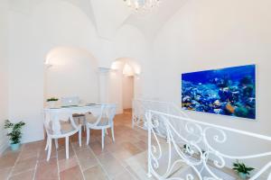 a white dining room with a table and chairs at Casa Malu in Positano