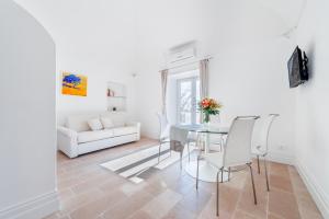 a white living room with a table and chairs at Casa Malu in Positano