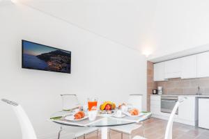 a white kitchen with a table with fruit on it at Casa Malu in Positano