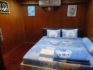 uma cama com almofadas Hello Kitty num barco em Ban Mae Arom em Amphawa