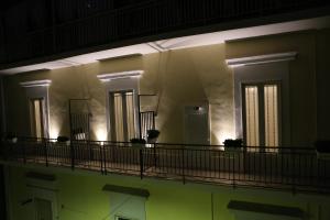 um edifício com uma varanda à noite com luzes em Novella 55 em Gravina in Puglia