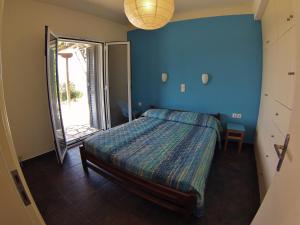 een slaapkamer met een bed en een blauwe muur bij Casa Nostos in Vasiliki
