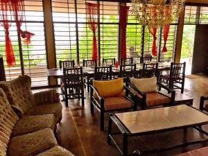 ケープ・コーストにあるKokodo Guest Houseのテーブルと椅子、シャンデリアのあるレストラン