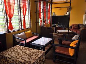 a living room with chairs and a table and a couch at Kokodo Guest House in Cape Coast