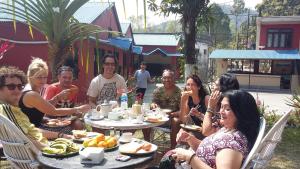 Un gruppo di persone seduti intorno a un tavolo che mangiano cibo di Trekkers Lodge a Pokhara Altre 37 foto