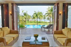 a living room with two couches and a pool at Furama Villas Danang in Da Nang