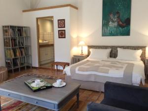 a bedroom with a bed and a table and a couch at Atelier Soleil in Moustiers-Sainte-Marie