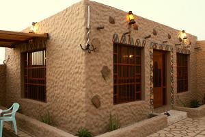 a home with a patio and a building at Al Reem Chalet in Al Ashkharah