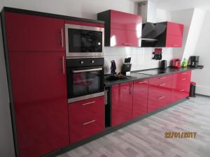バート・ハルツブルクにあるFeWo Witt Annenburgの赤いキッチン(黒い家電製品、赤いキャビネット付)