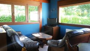 Casa Rural Ibarrondo Etxea في موغاينا: غرفة معيشة مع كرسيين جلديين وتلفزيون