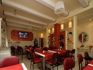 a restaurant with red chairs and tables in a room at Villa Lauda B&B in Rimini