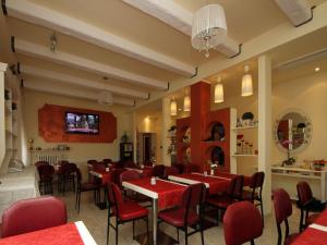 リミニにあるVilla Lauda B&Bの赤い椅子とテーブルが備わるレストラン