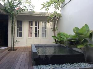 a courtyard with a pond in front of a house at The Patio Yogya in Yogyakarta