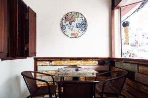 a table and chairs in a room with a plate on the wall at Sojourn Beds & Cafe in Taiping