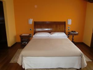 a bedroom with a large bed with an orange wall at Locanda da Gerry in Castelcucco
