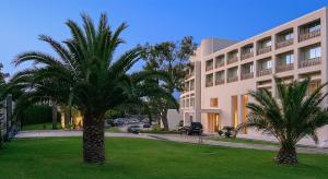 a palm tree in front of a building at Plaza Resort in Anavyssos