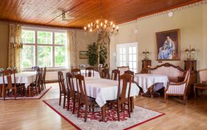 a dining room with tables and chairs and a chandelier at Backbyn Kartano in Espoo