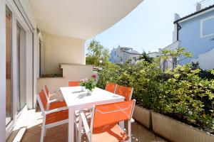 a balcony with a white table and chairs and plants at Villa Martina in Fregene