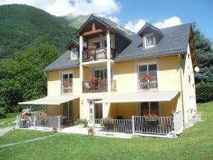 une grande maison jaune avec des fleurs sur les balcons dans l'établissement Chambres d'Hôtes La Balaguère, à Cauterets