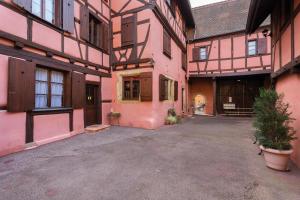 un patio vacío de un edificio con edificios rosados en Baribal'ele en Colmar